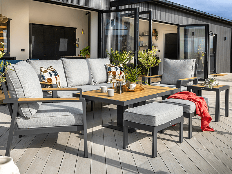 Hartman Rio 3 seat lounge set presented on a rug topped wooden patio with garden in background