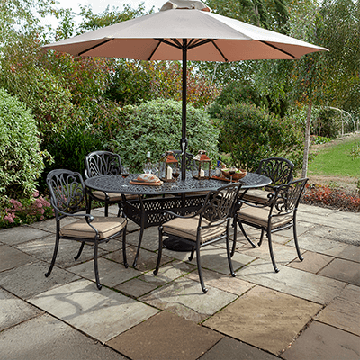 Image of Hartman Amalfi 6 seater dining set with oval table with a bronze toned metal frame and amber coloured seat cushions, in a garden setting