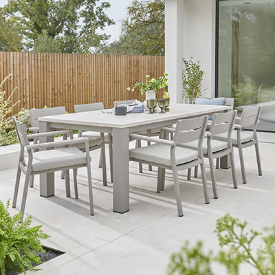 Studio image of Kettler Marina 6 seater dining set in a light grey colour, with cushioned seat pads and a rectangular wood effect topped table