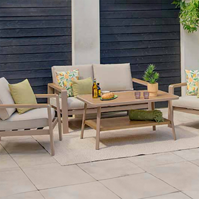 Image of LG Sorrento Lounge Set with sofa, 2 chairs and coffee table on a stone patio with a fence behind